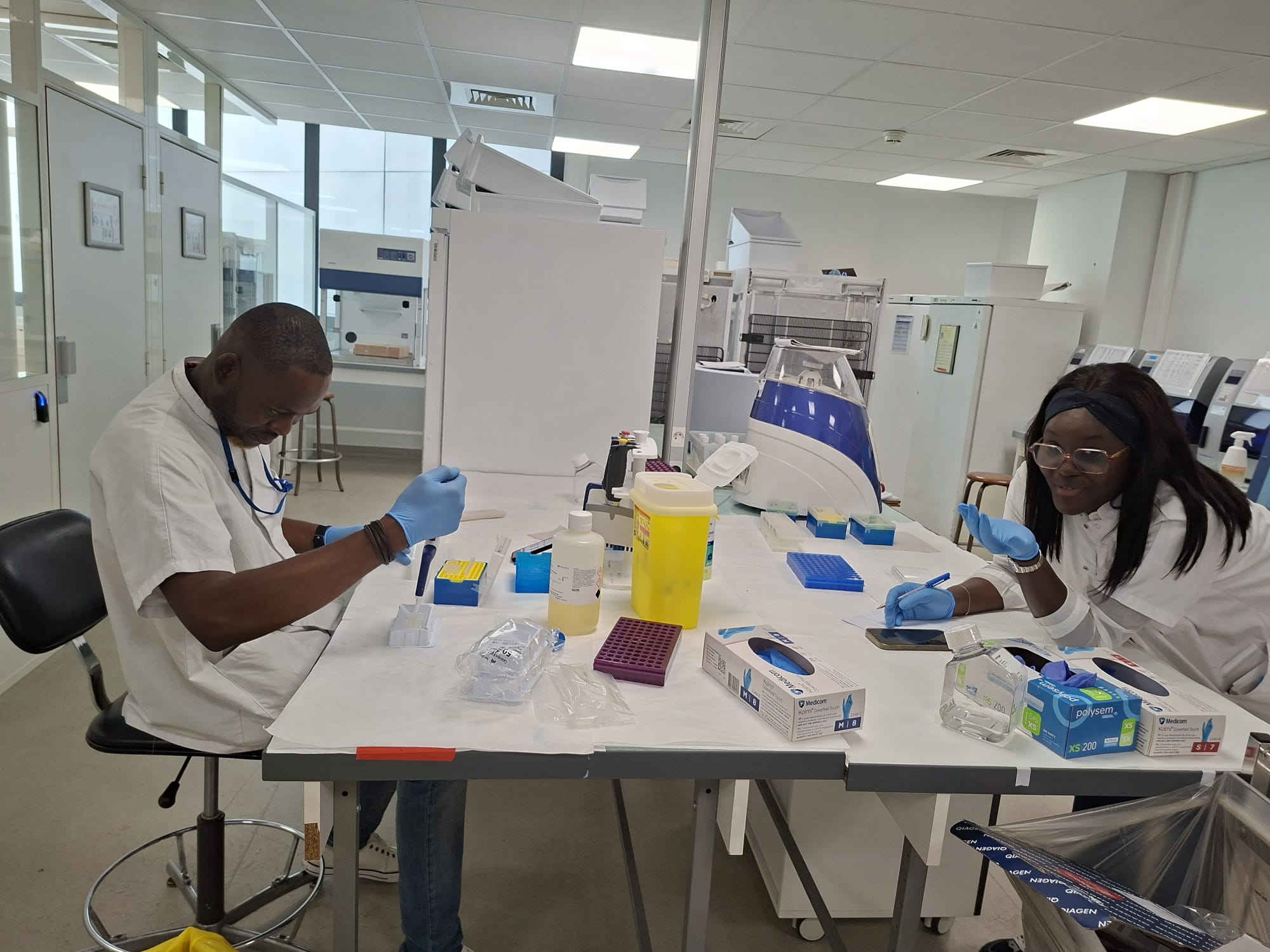 Deux chercheurs pipettant et documentant des échantillons dans un laboratoire